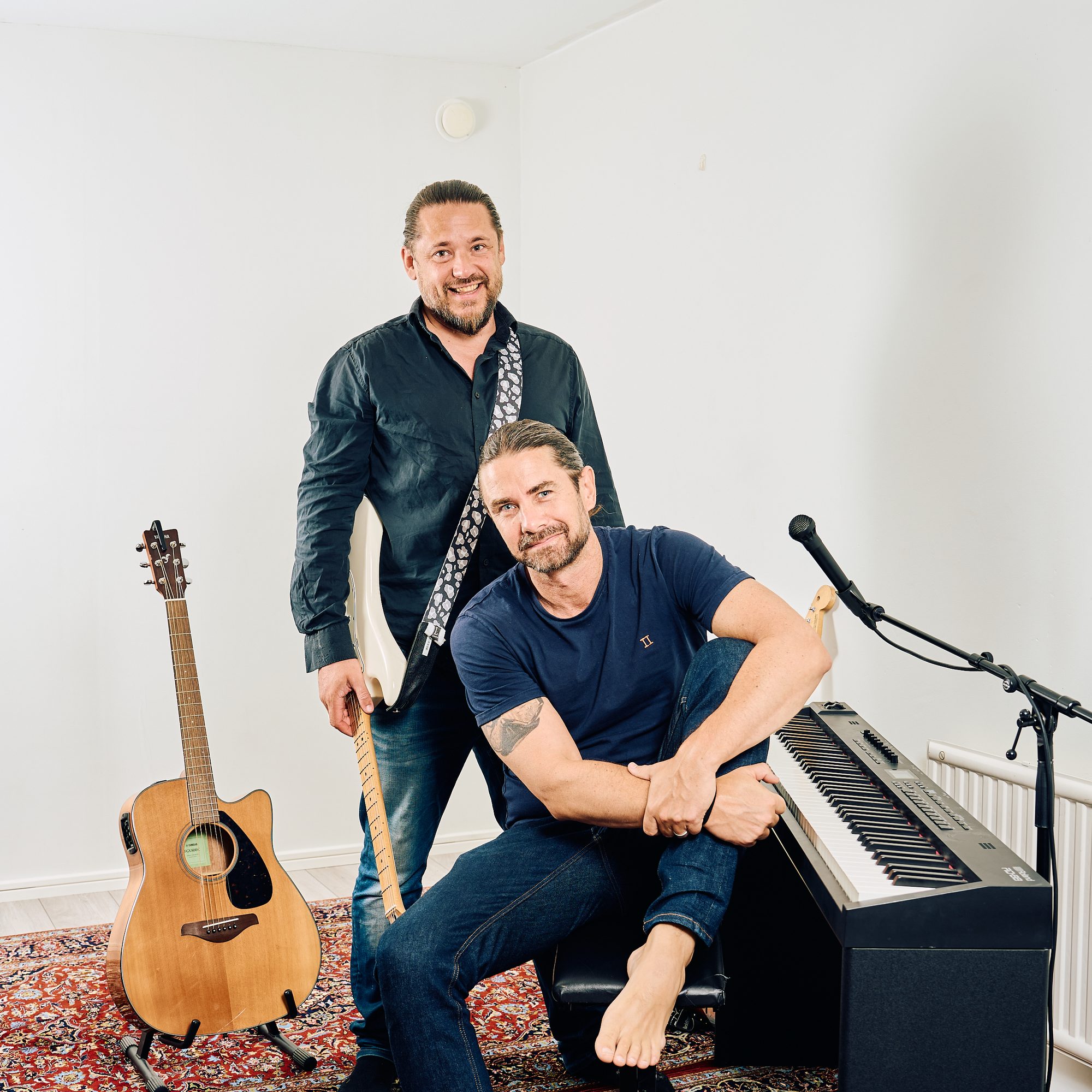 Gitarr, piano och två killar i en vit studio
